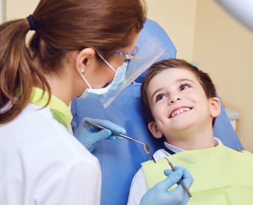 Pediatric Dentist looking at patient
