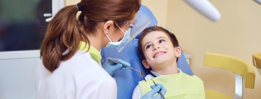 Pediatric Dentist looking at patient